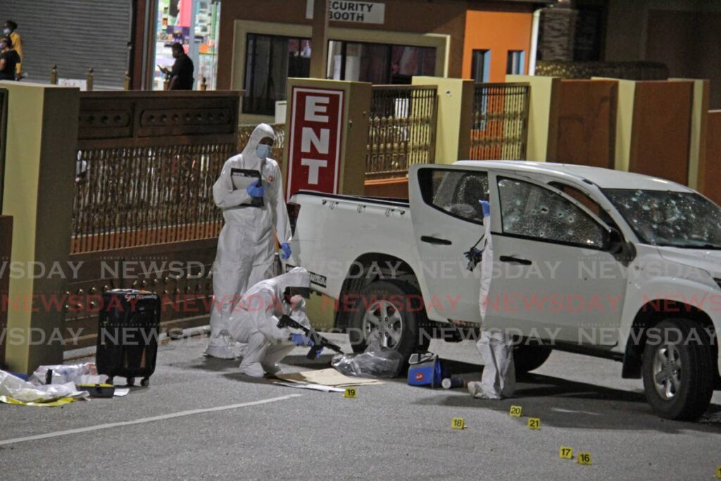 FLASHBACK: Police and crime scene investigators near the bullet-riddled van in which two security guards were killed after they were attacked by bandit shortly after leaving the Pennywise Super Centre in La Romaine on September 19. FILE PHOTO - 