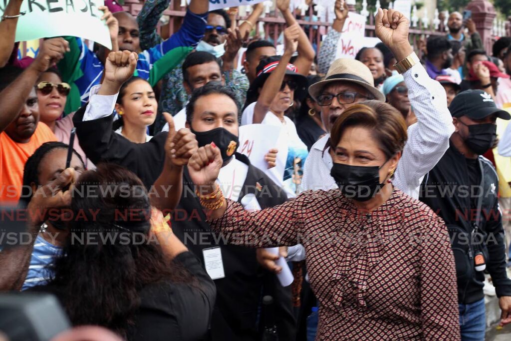 Opposition Leader Kamla Persad-Bissessar greets protesters who gathered outside Parliament on Monday ahead of the budget reading by Finance Minister Colm Imbert. - Photo by Roger Jacob