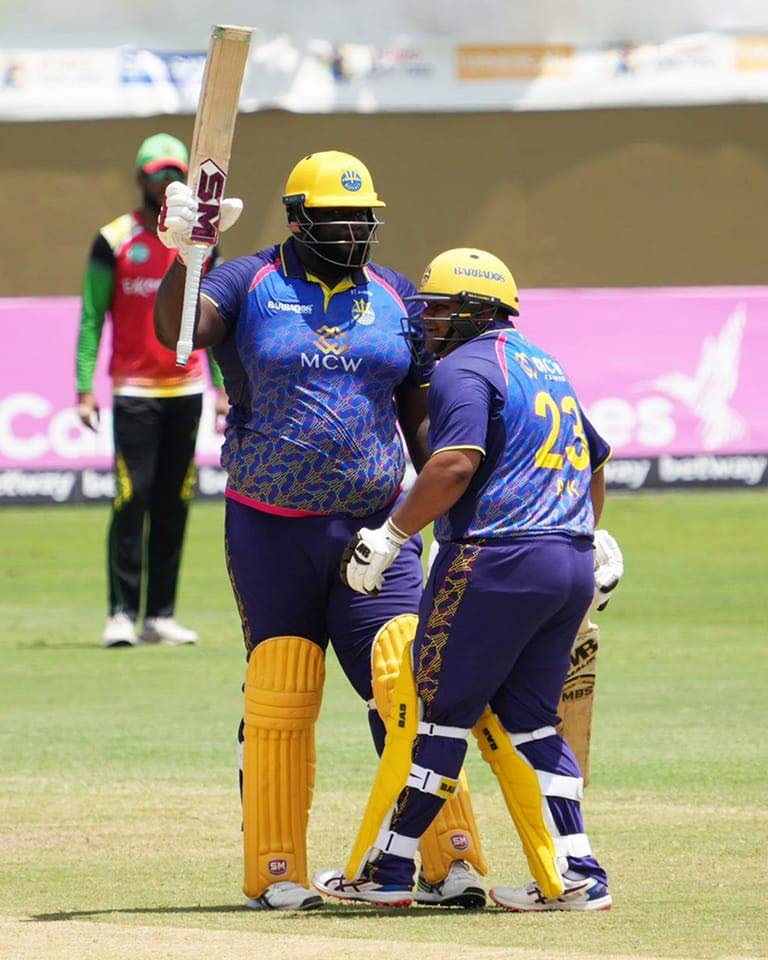 Rahkeem Cornwall (centre) of Barbados Royals raises his bat after reaching his half-century, while his teammate Azaam Khan congratulates him, during their team's Hero Caribbean Premier League qualifier against the Guyana Amazon Warriors, on Tuesday, at the Providence Stadium, Guyana. PHOTO COURTESY BARBADOS ROYALS. - 