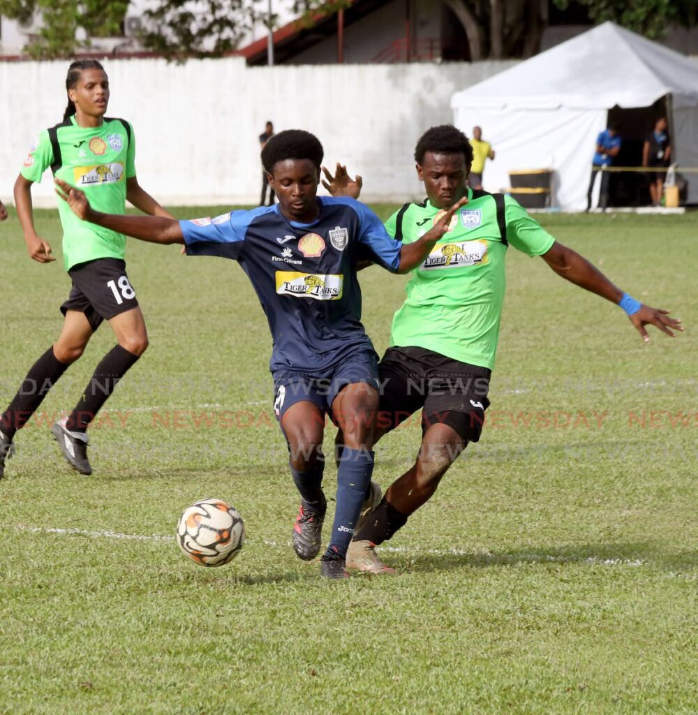 Queen’s Royal College’s Stephon James (L) and Malick’s Malachi Woodley vie for control of the ball during the SSFL match, on Wednesday, at CIC grounds, St Clair. Photo by Sureash Cholai