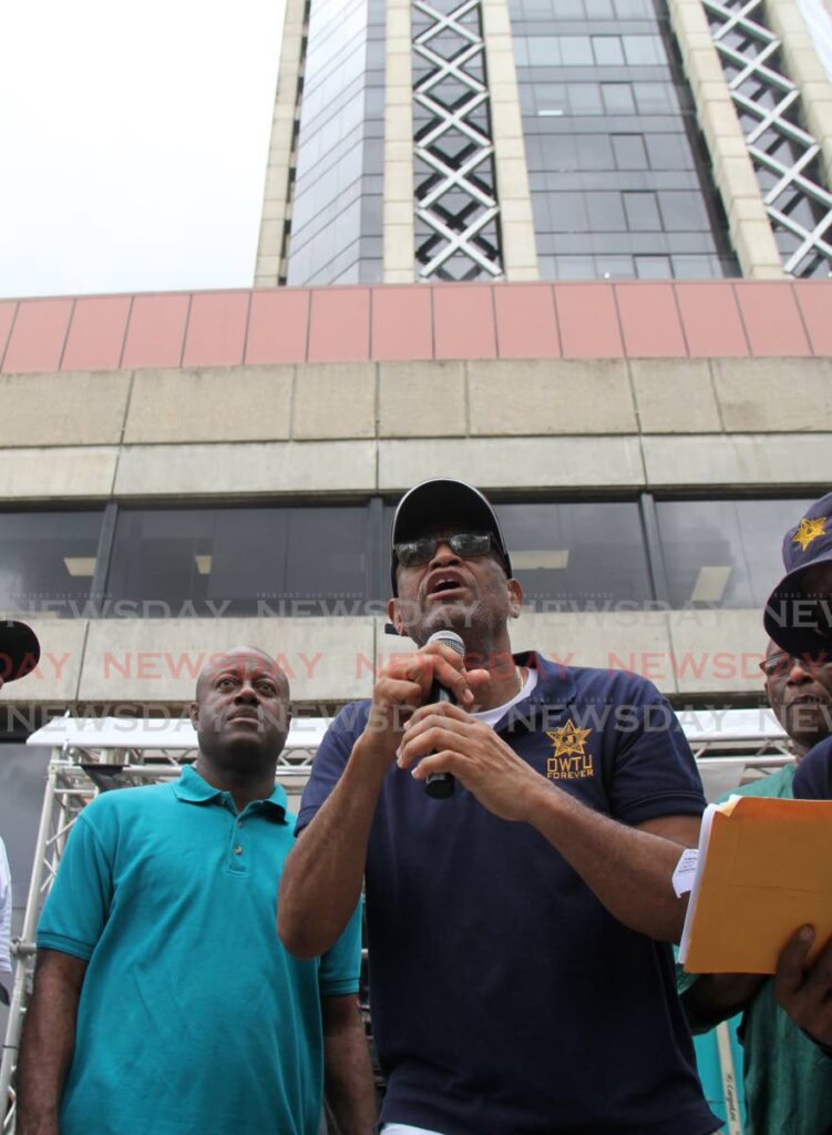JTUM head Ancel Roget speaks to marchers outside the Financial Towers in Port of Spain. At left is Prison Officers Association head Ceron Richards. PHOTO BY AYANNA KINSALE - 