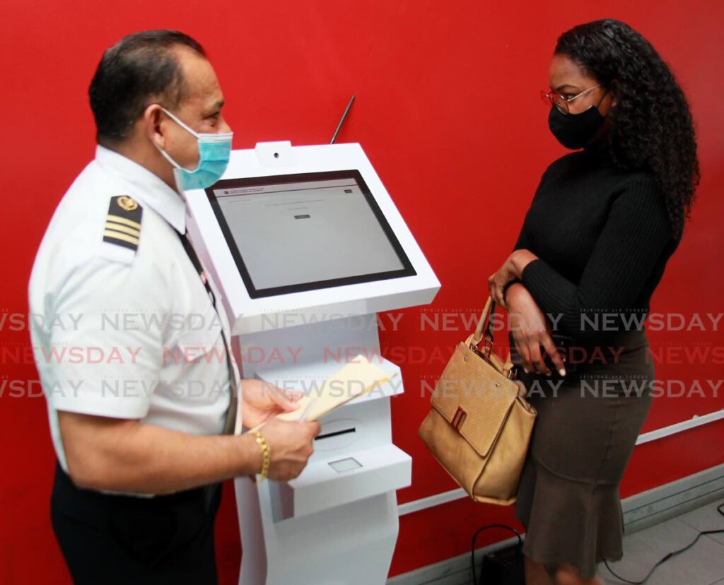 In this March 2021 file photo, Kishore Katwaroo, senior automotive licensing officer, shows Newsday's Elizabeth Gonzales the new computerised appointment booking kiosk, which uses the Q-management system, at the Caroni licensing office. At that time Katwaroo said by April 2021, all licensing offices would have Q-management systems and kiosks would have been distributed on the basis of the flow of customers at each office. File photo/Roger Jacob