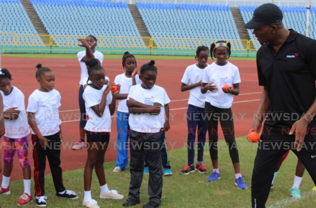 In this July 10, 2017 file photo, Keshorn Walcott gives pointers to children who took part in the Atlantic National Primary Schools Track and Field Development camp, at the Hasely Crawford Stadium, Mucurapo. 