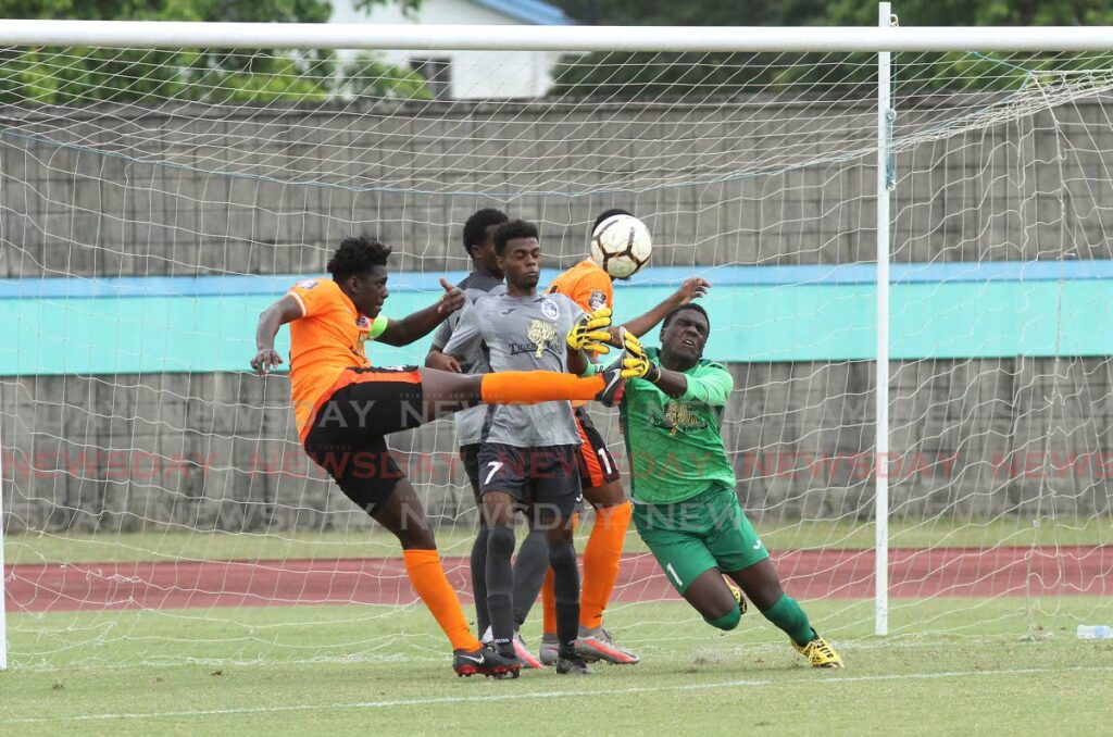 Sando Club's Thaj Neptune (left) makes an attempt to score as Police Youths' Da Jean Collingwood (R) tries to hold the ball during the Tiger Tanks Under-20 Invitational Tournament at the Manny Ramjohn Stadium, Tarouba, on May 14. - Photo by Ayanna Kinsale