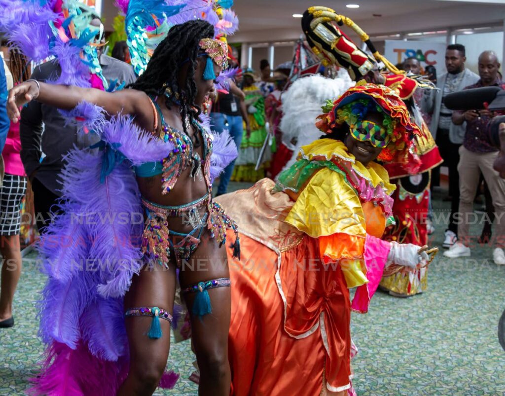 A masquerader, left, dances with a dame Lorraine at the Tobago carnival launch at Shaw Park Cultural Complex.  Photo by David Reid