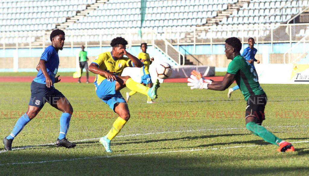 In this September 9 file photo, Presentation San Fernando's Caleb Boyce (centre) chips the ball over the Naparima goalkeeper during an exhibition match at the Ato Boldon Stadium, Couva. - Lincoln Holder