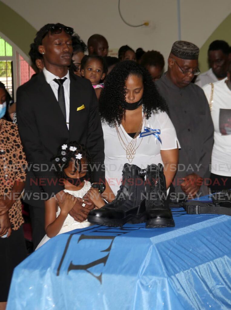GOODBYE: The family of murdered security guard Jeffrey Peters, including son Jeffrey Jr, left, daughter Jenique, and wife Amanda Beharrysingh, stand at his coffin on Monday during his funeral. Photo by Sureash Cholai