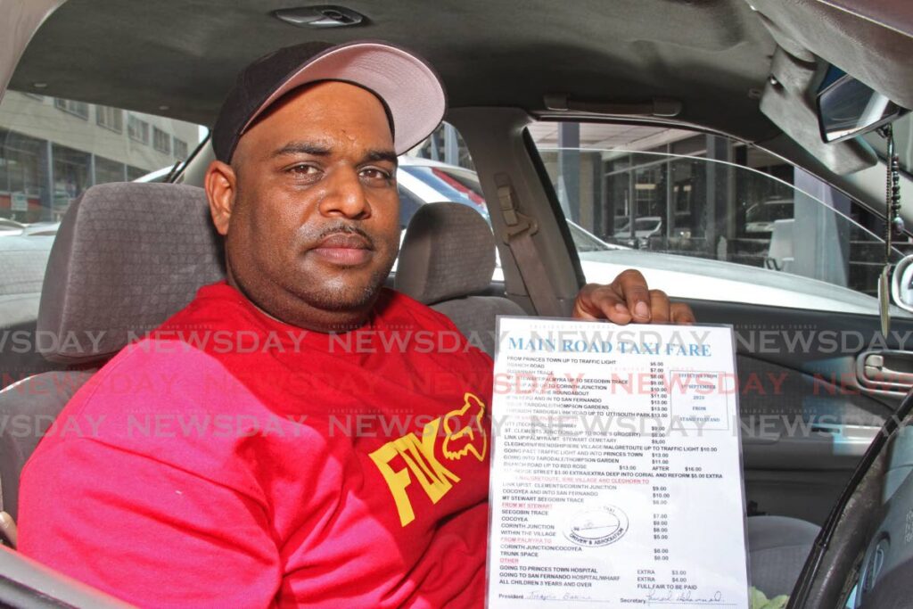 Shane Sookoo, member of the Main Road Taxi Association shows the existing tariff (fare) sheet. It is expected that the fares will increase by $1 as of October 17. - Photo by Marvin Hamilton
