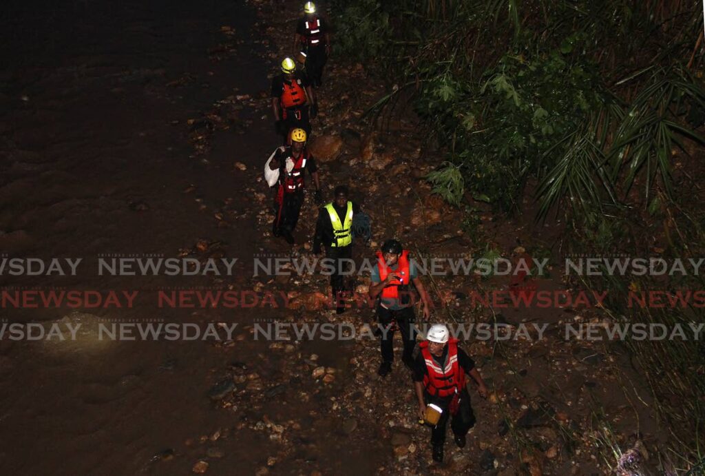 SEARCH: Members of the Fire Service's Search and Rescue Unit during a search Wednesday night in the Surrey River in Lopinot for Theresa Lynch who was swept away earlier that day. - Photo by Ayanna Kinsale 