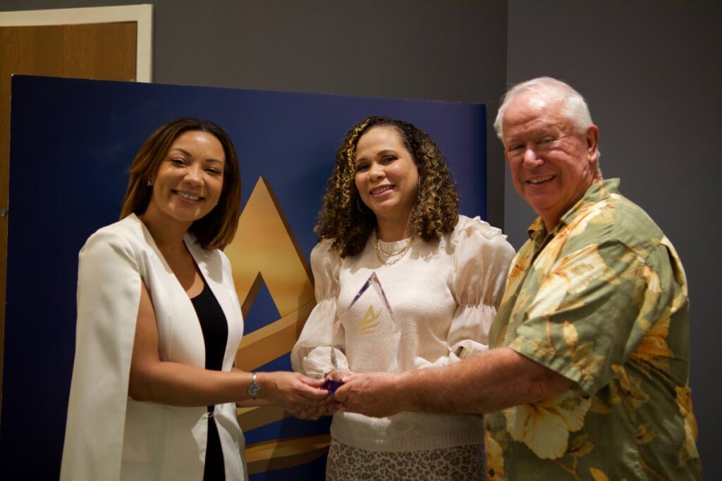Stacey Ryan, director, client services, Ross | Rethink, left, and Ayesha Boucaud-Claxton, head, group branding and communications, Guardian Group, centre, receive the Angel Awards Best of Show trophy from Angel Awards chairman Mike Weber, right, for Happytalism.
 