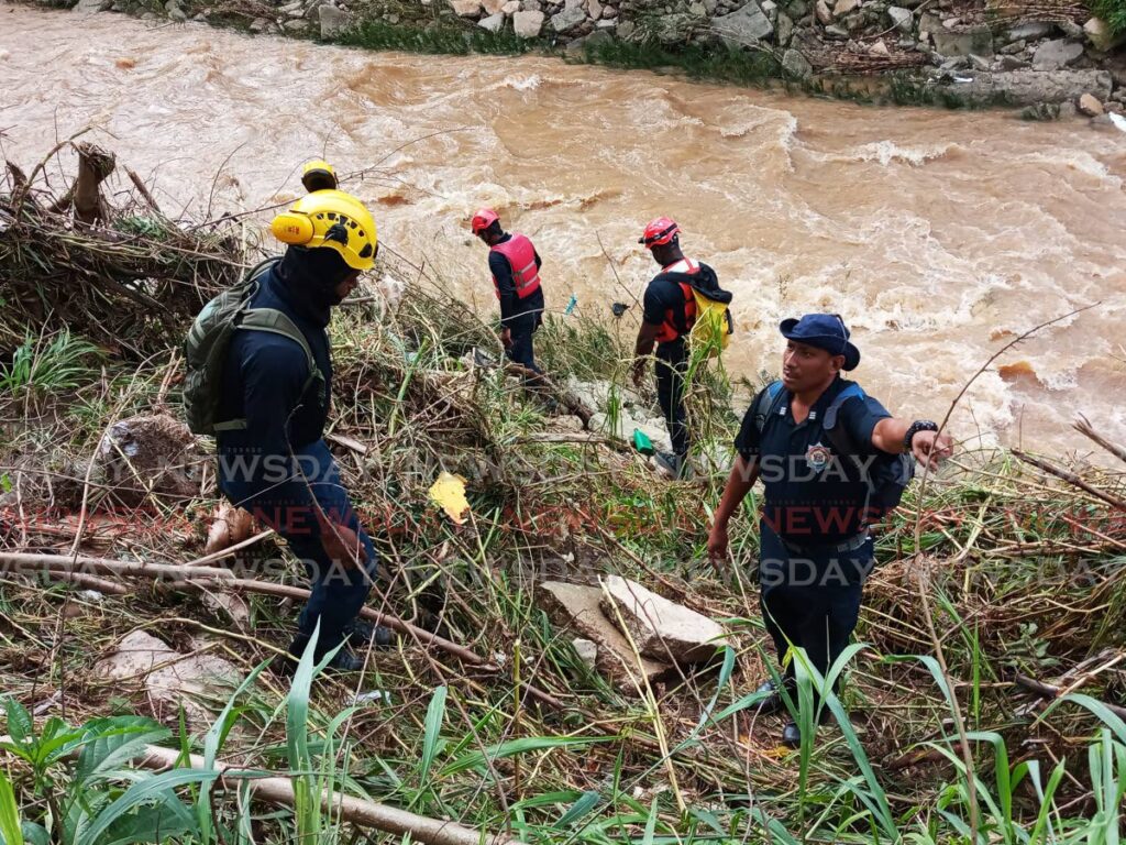 Fire officers search for the body of Theresa Lynch in the Caroni River, Trincity last Thursday.  File photo/Angelo Marcelle