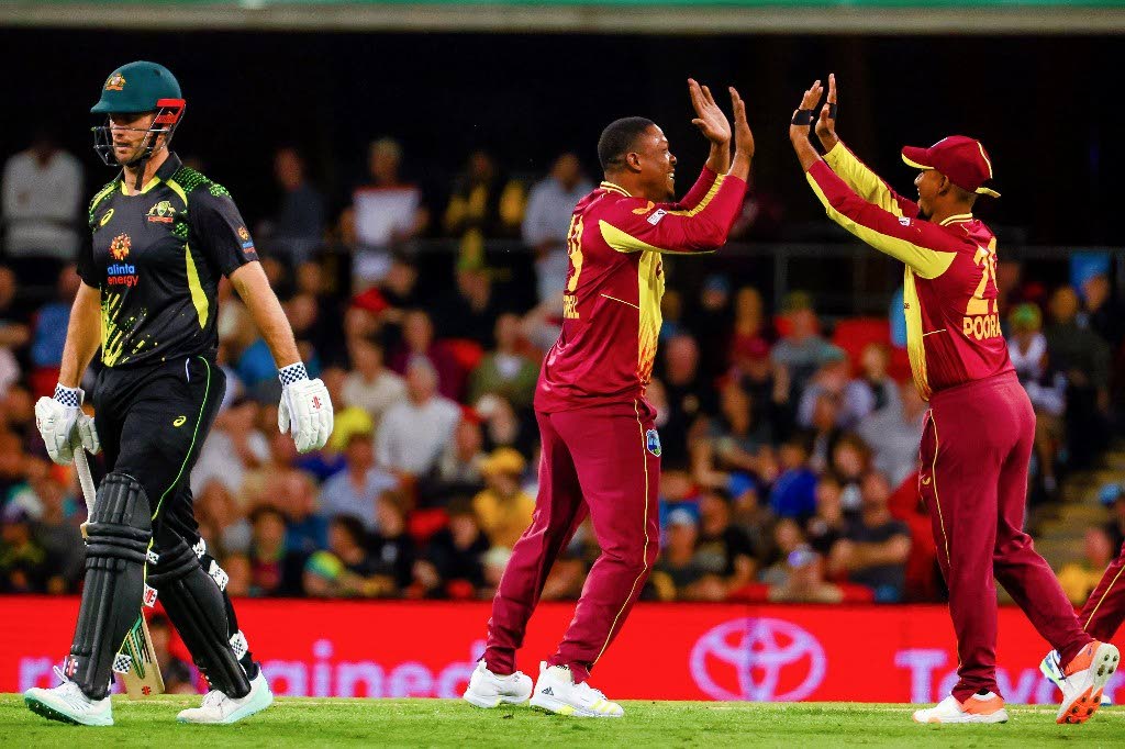 Australia’s Mitchell Marsh (L) departs as Sheldon Cottrell (C) of West Indies celebrates his wicket during the opening cricket match of Twenty20 series between Australia and West Indies at Metricon Stadium, Gold Coast on Wednesday. - 