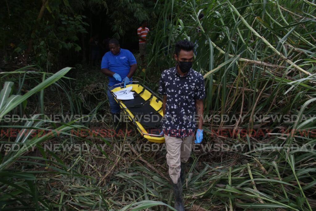 Undertakers arrive to remove the body of Theresa Lynch from the Arouca River. - Photo by Angelo Marcelle