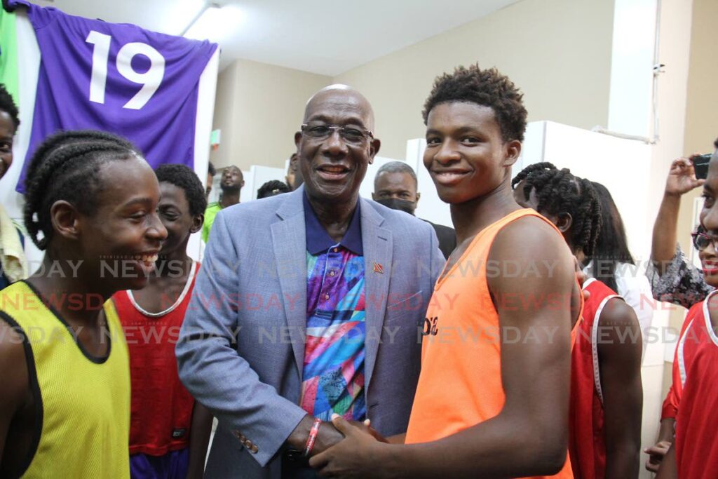 Prime Minister Dr Keith Rowley chats with some young men at the opening of the Mahaica Sporting Complex, Pt Fortin on Saturday.  - Marvin Hamilton