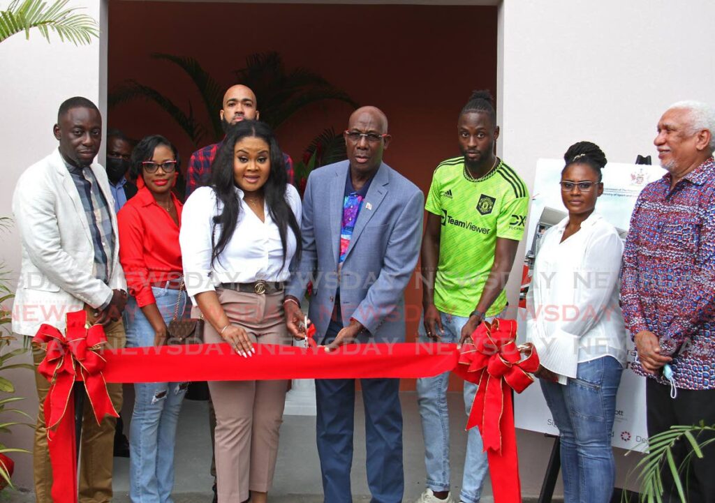 Prime Minister Dr Keith Rowley, centre, assisted by Sports Minister Shamfa Cudjoe cuts the ribbon for the opening of Mahaica Sports Complex on Saturday in Point Fortin. - Marvin Hamilton