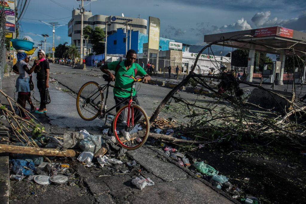 In this file photo a man carries a bicycle while crossing a barricade in Port-au-Prince, Haiti, on October 12, 2022. AP PHOTO