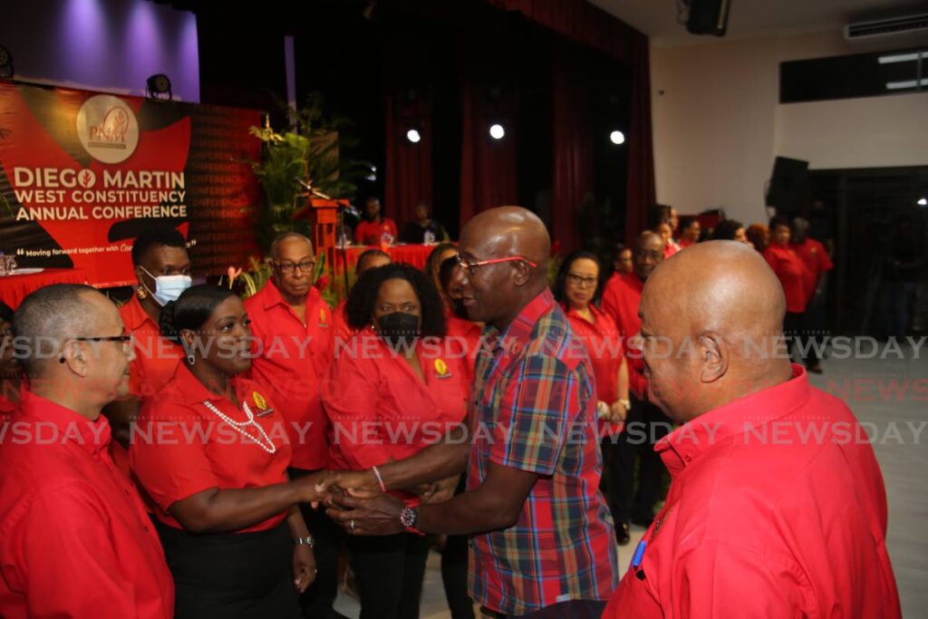 Prime Minister Dr Keith Rowley, second from right, greets supporters on Wednesday at a meeting at the Diego Martin South Community Centre, Four Roads, Diego Martin. - Sureash Cholai