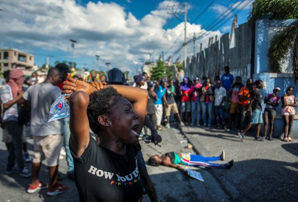 A woman cries near the body of another woman fatally shot by the police during a protest demanding the resignation of Prime Minister Ariel Henry in the Delmas area of Port-au-Prince, Haiti, on October 10. (AP Photo/File) - 