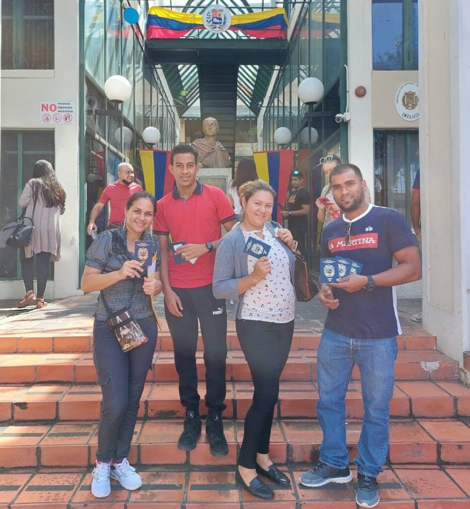 Yanetzis Da Costa, Alfredo Bastidas, Katiuska Pantoja and Lizardis Navarro show their Venezuelan passports delivered by their country's embassy in Port of Spain. Photo by Grevic Alvarado