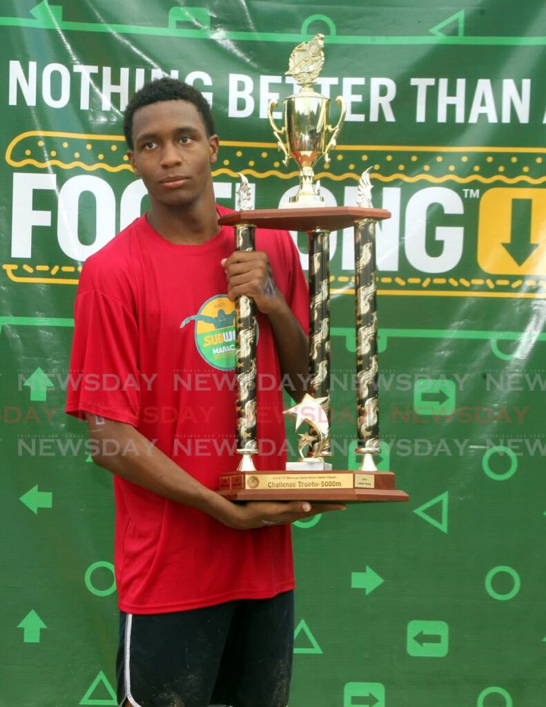 Marlins Aquatics’ Nickolai Blackman holds the winner’s trophy after completing the Subway Open Water Classic 5,000m swim in 1:11:36, on Sunday, at Maracas Bay. - ANGELO MARCELLE