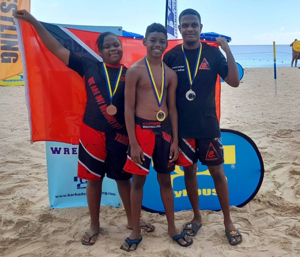 TT's Renee Fortune (L), Che'Don Grant (C) and Seon Adhar captured three medals at the Beach Wrestling Tournament hosted by the Barbados Wrestling Association, at Brandon's beach, Barbados, on Saturday. - 