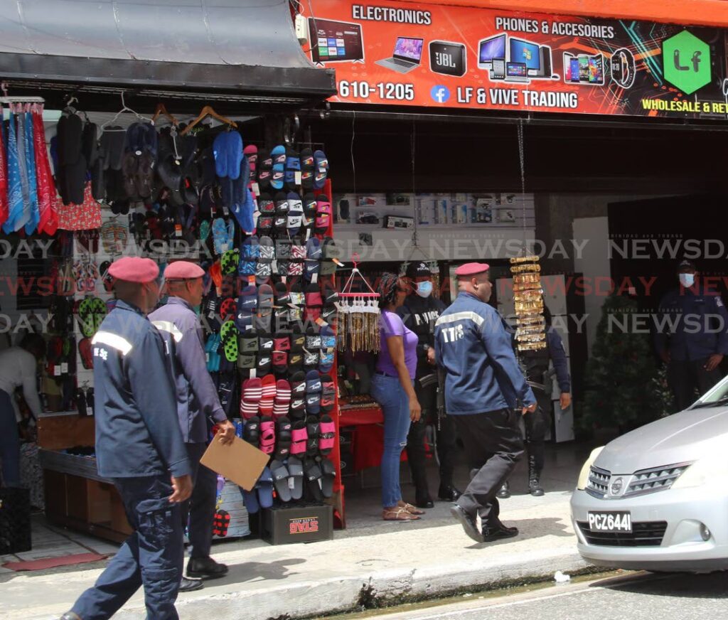 Members of the Trinidad and Tobago Bureau of Standards , the police and fire service officers raided LF Trading store and warehouse on Charlotte Street in Port of Spain. Photo by Sureash Cholai