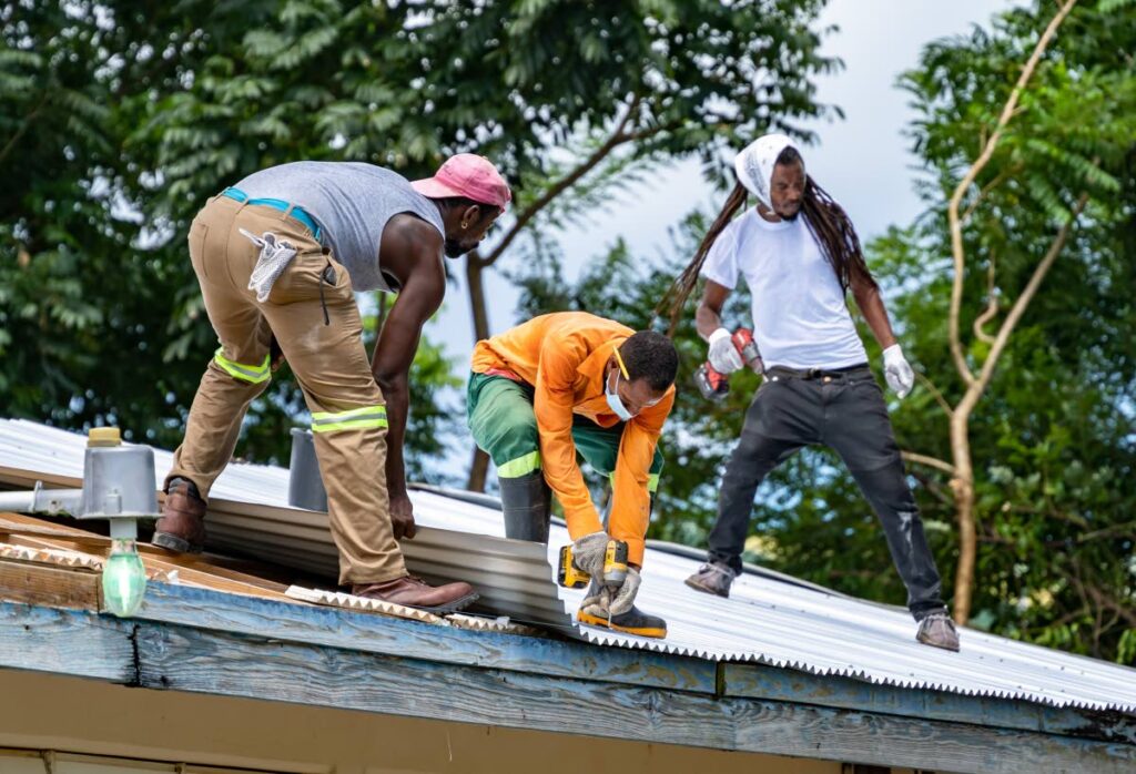 URP workers on the roof of the UWI Distance Education Centre building in Signal Hill.  - DIQUD