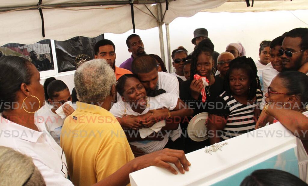 DEEP GRIEF: Mourners grieve near the coffin of nine-year-old murdered schoolboy Jomol Modeste at his funeral on Friday which was held at his Enterprise, Chaguanas home. PHOTO BY MARVIN HAMILTON - 