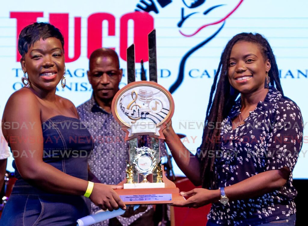 Secretary of Tourism and Culture Tashia Burris, right, presents Nicole Thomas with her trophy after winning the inaugural Tobago carnival TUCO calypso monarch on Sunday at Shawl Park Cultural Complex.  - David Reid