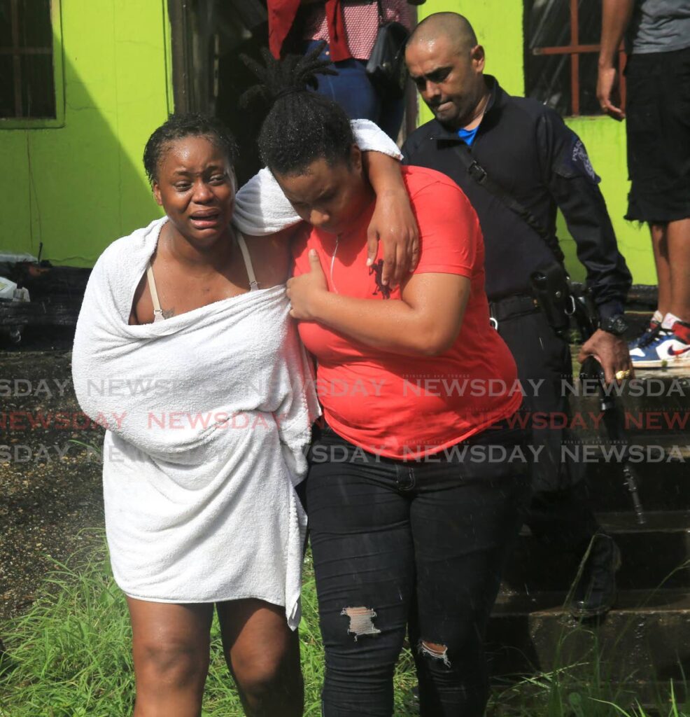 IN AGONY: Krystal Braithwaite, mother of two-year-old Kimani Douglas, had to be consoled after the boy perished in a fire at the family's Petunia Drive, Morvant, home on Monday. - Photo by Angelo Marcelle