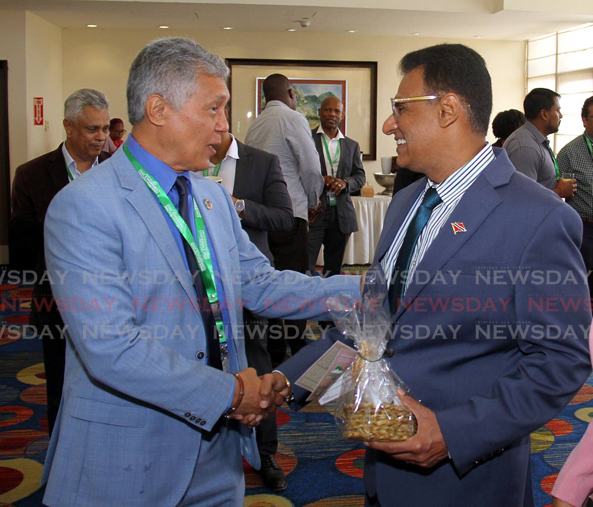 Minister of Works and Transport Rohan Sinanan, right, is greeted by senator Anthony Vieria during the IAMovement Green Infrastructure Conference at Hilton, Port of Spain. 2022.10.25
