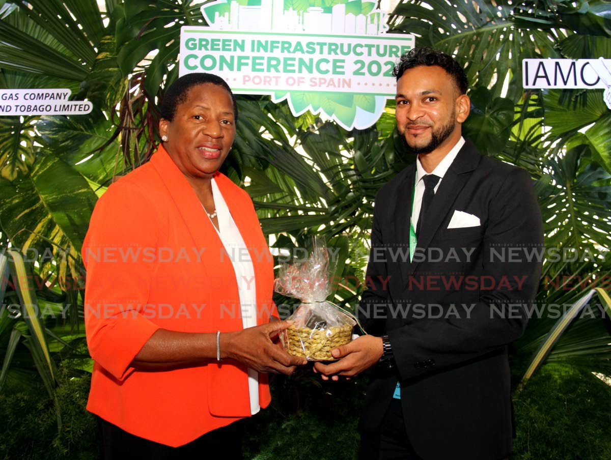 Managing director of the IAMovement presents Minister of Planning and Development Pennelope Beckles-Robinson with a basket made with vetiver grass at the IAMovement Green Infrastructure Conference at Hilton, Port of Spain. 2022.10.25