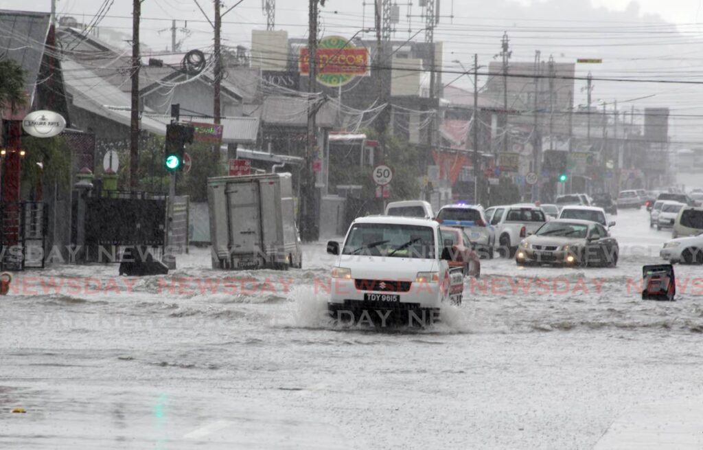Not to be delayed on Tuesday, this delivery pickup pushes through flood waters on Ariapita Avenue. Photo by Roger Jacob