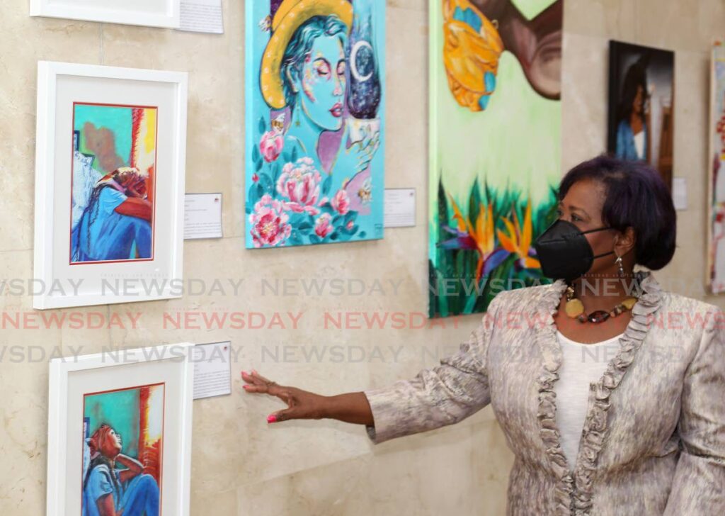 Speaker Bridgid Annisette-George examines the art on display at the launch of the Red House Rotunda Art Gallery's Healing Through Art display on Wednesday. - ROGER JACOB