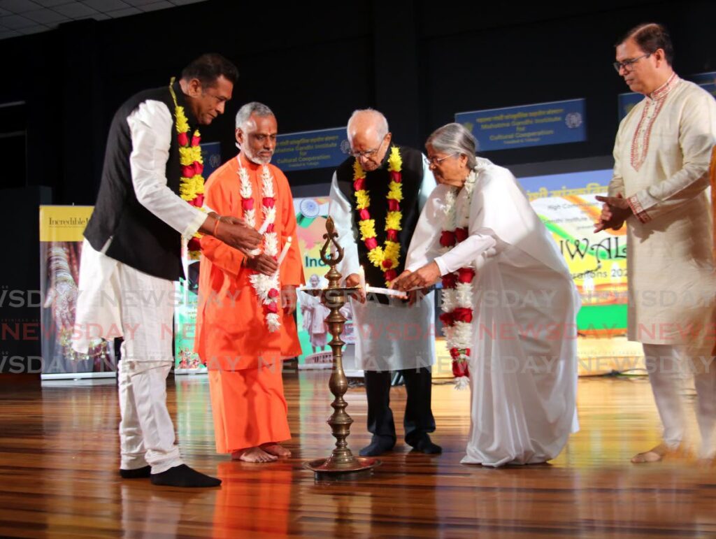  Raju Sharma, charge d'affaires at the High Commission of India, right, looks on as Senator Deoroop Teemal, from left, Swami Prakashananda, Dr Deokinanan Sharma and Sister Hemalatha light a lamp at the High Commission’s Divali celebrations at the Mahatma Gandhi Institute for Cultural Cooperation in, Mt Hope on Friday.  - Photo by Sureash Cholai