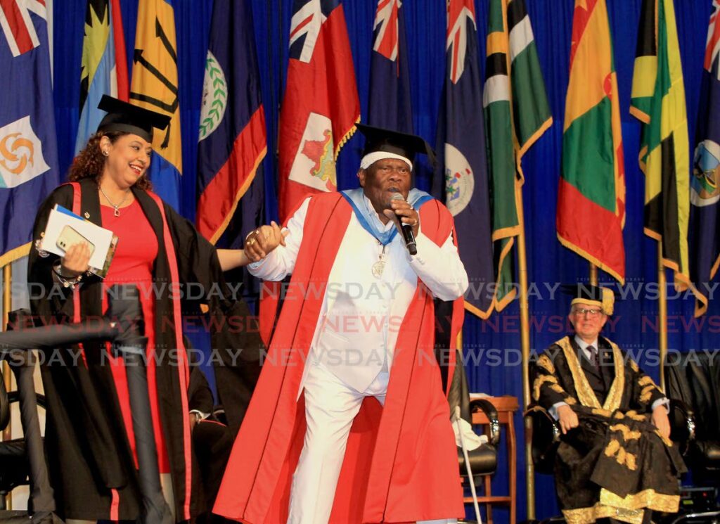 Veteran calypsonian Lord Nelson encourages campus registrar Dawn-Marie De Four-Gill after he was conferred with an honorary doctorate by the UWI at the graduation ceremony  for the Facultyr of Humanities and Education at the Centre of Excellence, Macoya on Saturday.  - ROGER JACOB