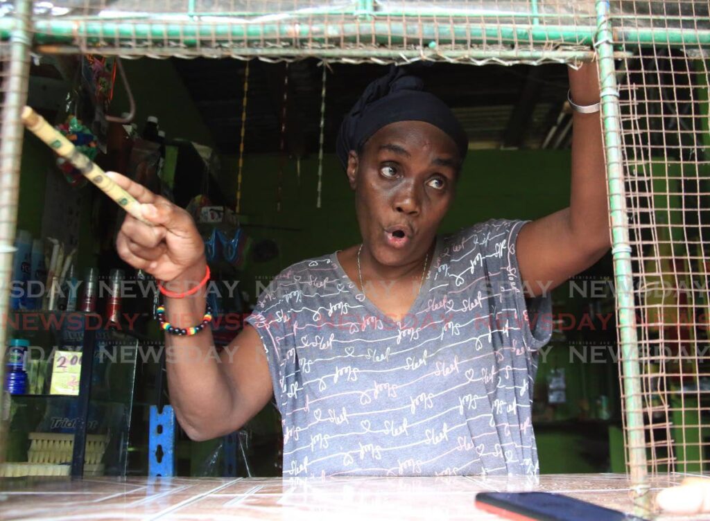 Michelle Bruce, mother of Ruben Subar, one of the two men shot dead at the carpark of a bar in St Helena on Sunday morning, speaks to Newsday through a window of her shop in Oropune Village, Piarco, on Sunday. - SUREASH CHOLAI