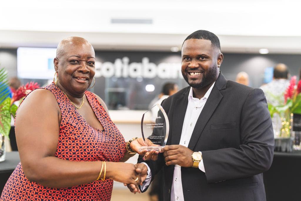 Charmaine Archer, left, owner, Canaan Nursery School receives an award from the new Scotiabank Lowlands branch manager Marlon White, for being one of the bank's long-standing business banking customers in Tobago, at a function last Thursday in Lowlands. - 