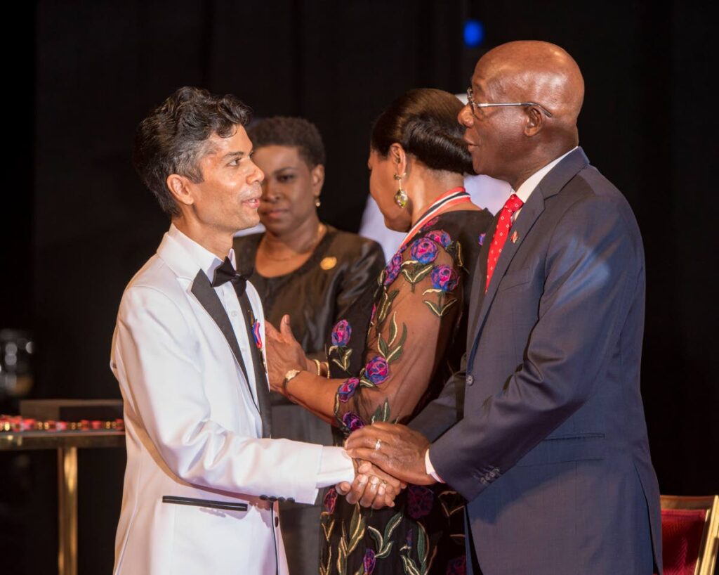 Prime Minister Dr Keith Rowley congratulates Dr Jerome Teelucksingh on his Hummingbird medal, gold, at the 2022 National Awards, NAPA, Port of Spain on September 24. President Paula-Mae Weekes is at centre. - Photo courtesy Office of the President