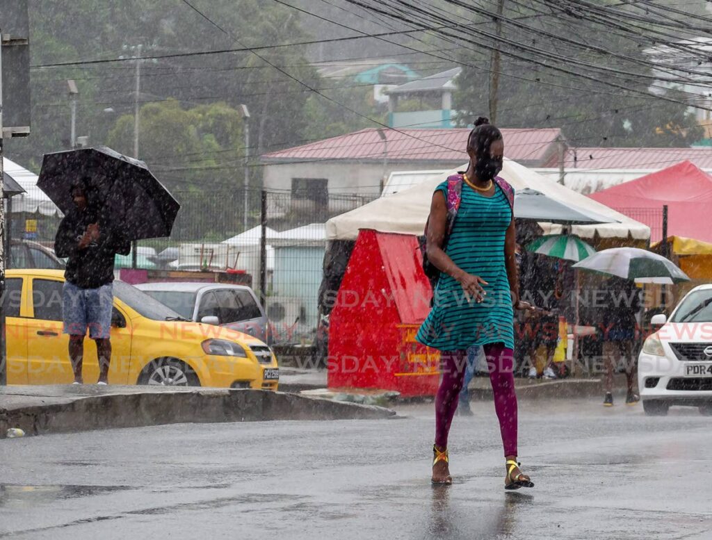 A woman walks through the rain without an umbrella along Carrington Street, Scarborough. - File Photo