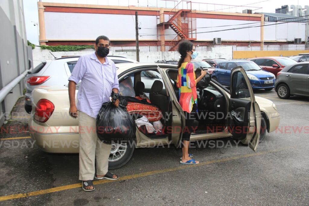 Vishwanath Niapaul and his common in law wife Chanelle Niapaul show their belongings which they store in their car. Photo Sureash Cholai