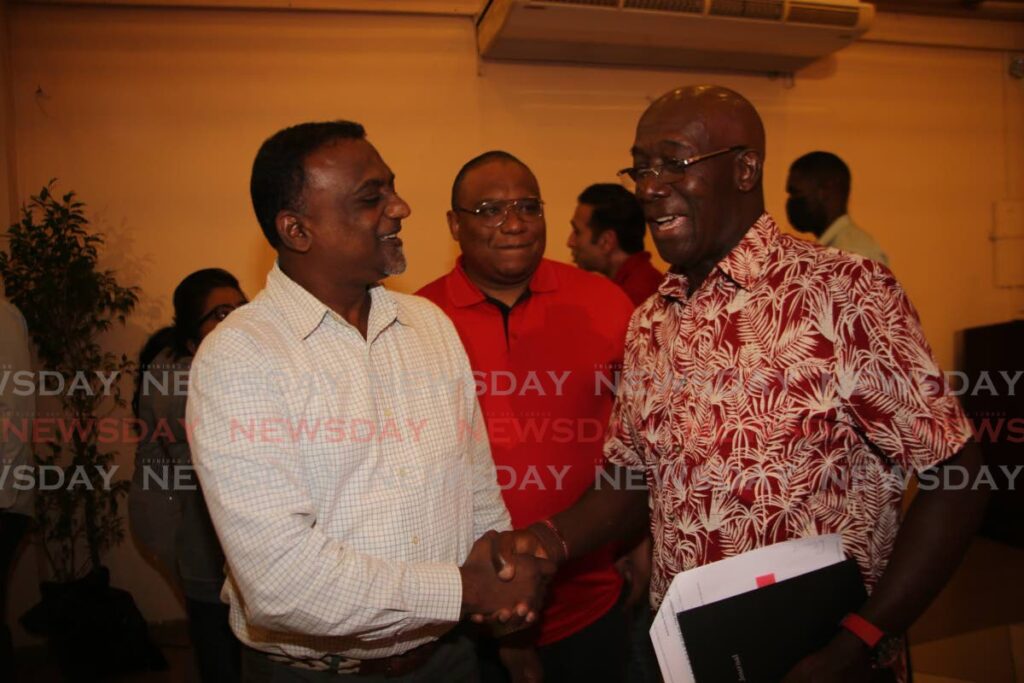 Prime Minister Dr Keith Rowley greets UNC councillor for Kelly Village/Warrenville Samuel Sankar, left, a PNM meeting at Signature Hall, Chaguanas, on Tuesday. PHOTO BY SUREASH CHOLAI - 