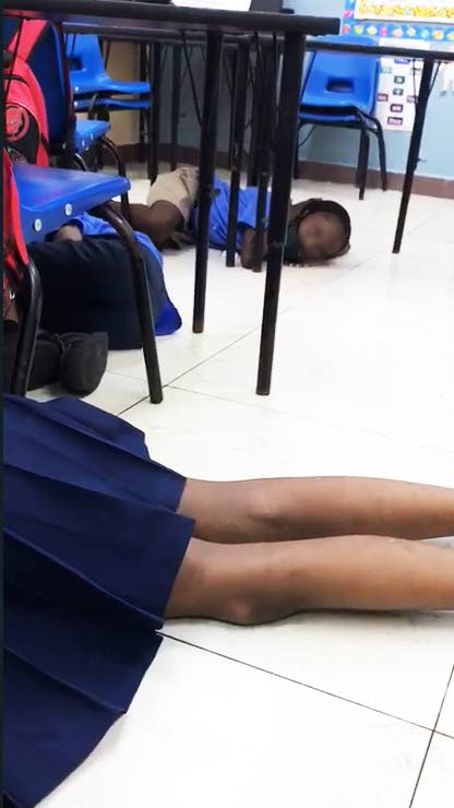 A screen grab from a video shared on social media on Wednesday, shows students of the Rose Hill RC Primary School on the floor in their classroom after being told by their teacher to take cover when rapid gunfire broke out near the school on Monday.  