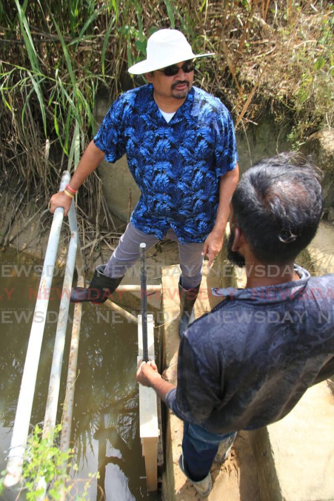 Chaguanas West MP Dinesh Rambally examines one of two fault flood falps at the Orange Grove Photo by ANGELO MARCELLE - ANGELO MARCELLE