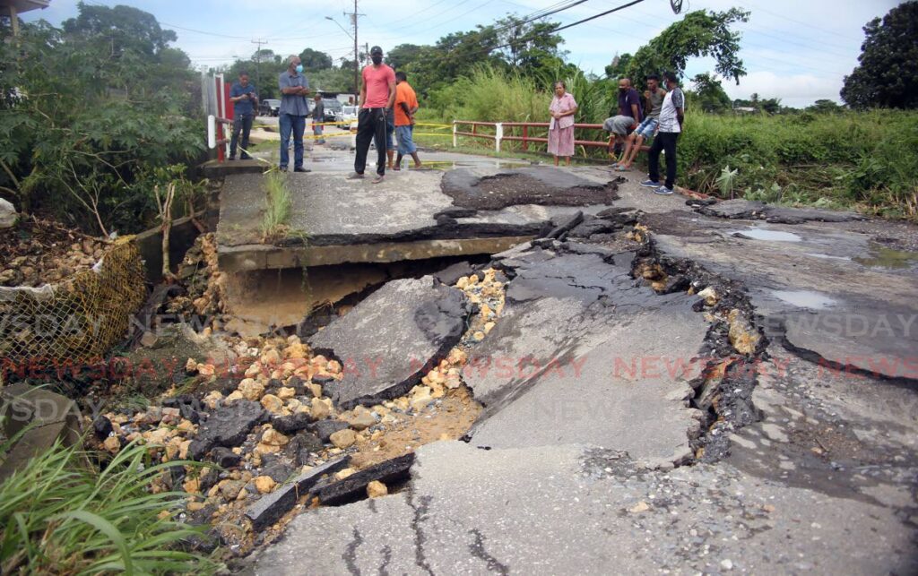 Villagers consider where to pass after the Mt Pleasant Road in Carolina Village, Couva, collapsed on Wednesday.  Photo by Lincoln Holder