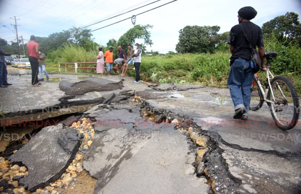 In this November 9 file photo, a resident crosses a collpased section of Mt Pleasant Road at Carolina Village, Couva. The road has since been repaired. - File photo
