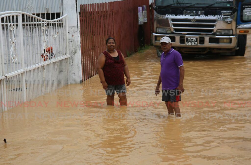 Resident Asha Deonarine with Councillor Nassa Hosein outside her flooded home on Neeranjan Street in Sangre Grande. - Photo by Sureash Cholai