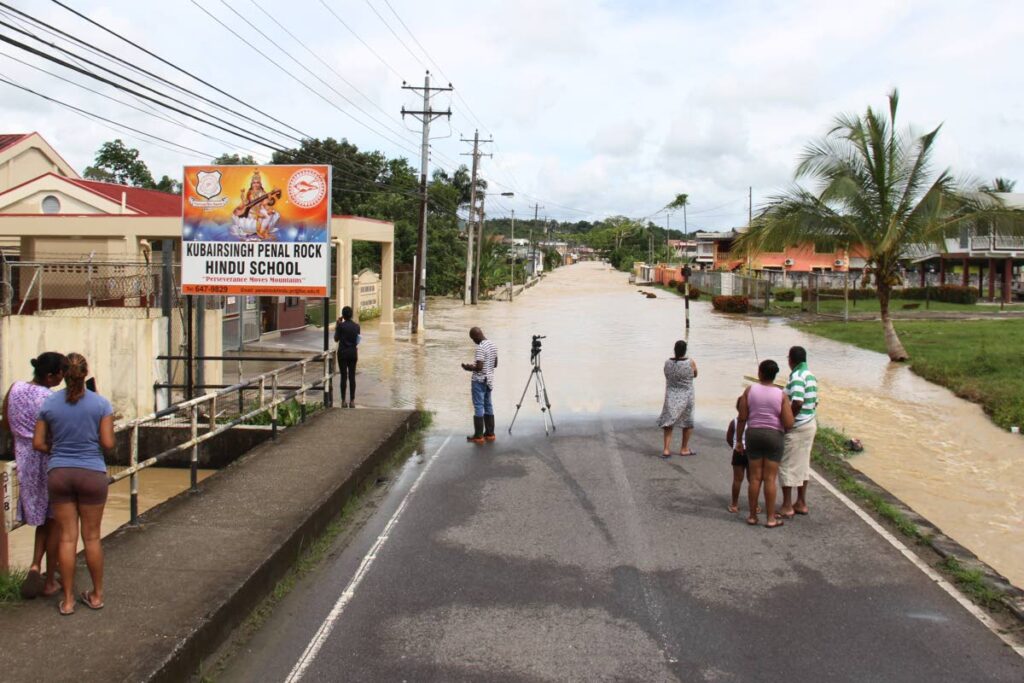 Residents of Penal Rock Road stranded by flood outside Kubairsingh Hindu Primary School on November 9. - Marvin Hamilton