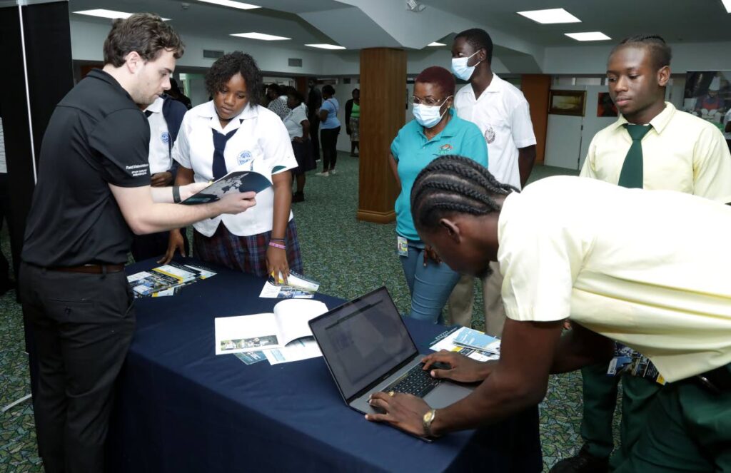 Reid Maisonneuve of Thompson Rivers University in British Columbia, Canada, talks with students about the academic options at UniFest Tobago College and University Fair 2022 at the Shaw Park Complex on Wednesday. - THA