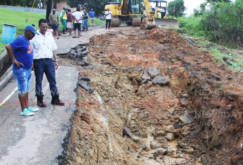 Works and Transport Minister Rohan Sinanan, 2nd from left, and councillow Gerald Debisette, left, at the site of the badly damaged road in Sobo Village, La Brea on Sunday. - Photo by Lincoln Holder